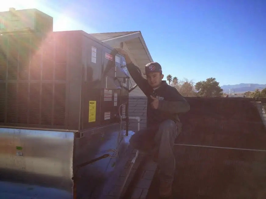 HVAC technician performing Air Duct Cleaning on a rooftop unit in Elk Grove